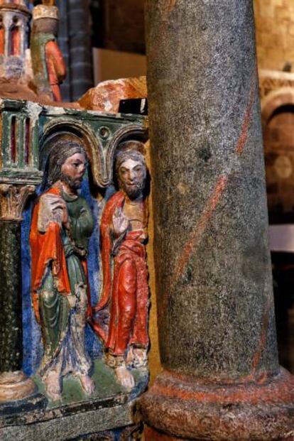 Un sensor de luminosidad, de color negro, sobre una de las figuras de piedra policromada del cenotafio de los santos, en la basílica de San Vicente.