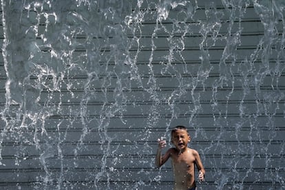 Un niño se refresca en una fuente en el parque KLCC bajo el caluroso día registrado en Kuala Lumpur (Malasia).