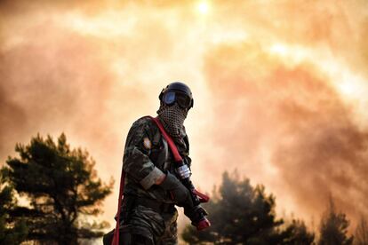 Un bombero trabaja en la extinción de un incendio cerca de Atenas (Grecia).