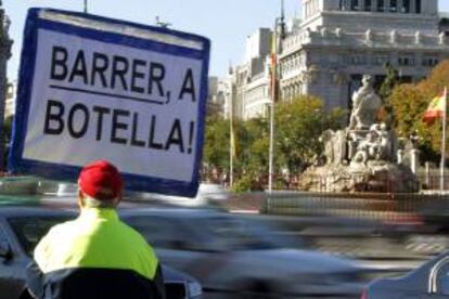 Un hombre porta un cartel contra la alcaldesa de Madrid, Ana Botella, en la Plaza de Cibeles, donde se encuentra el Ayuntamiento madrileño.