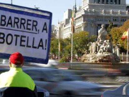 Un hombre porta un cartel contra la alcaldesa de Madrid, Ana Botella, en la Plaza de Cibeles, donde se encuentra el Ayuntamiento madrileño.