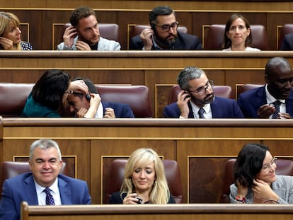 Diputados socialistas se colocan los auriculares de traducción, el día 19 en el Congreso de los Diputados.