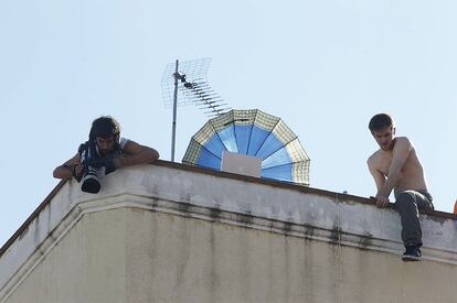 Algunos manifestantes se han encaramado al edificio de Anuar, en la calle Naranjo del barrio de Tetuán. La protesta también ha reunido a multitud de medios de comunicación.