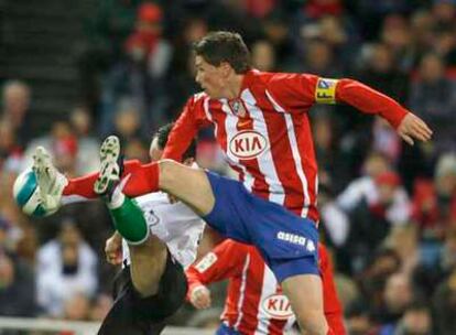 Fernando Torres pugna por el balón con Munitis.