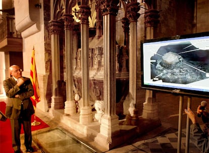 El consejero Tresserras en Santes Creus, junto a la tumba del rey Pere el Gran y la imagen que muestra su momia.