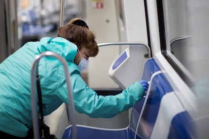 Una usuaria limpia su asiento antes de utilizarlo, en el Metro de Barcelona, este martes.