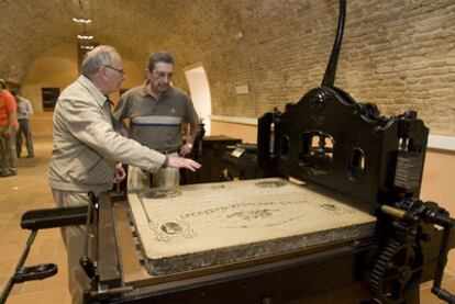 Dos visitantes observan, ayer, una prensa manual en el Museo Litográfico de Cádiz.