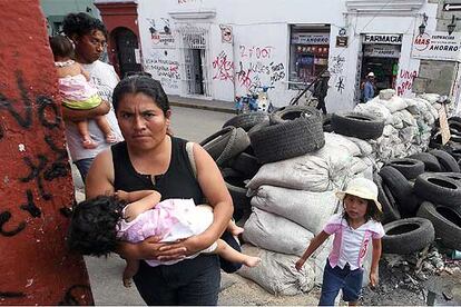 Una familia cruza una barricada del movimiento de protesta de Oaxaca, el pasado martes.