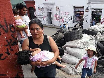 Una familia cruza una barricada del movimiento de protesta de Oaxaca, el pasado martes.