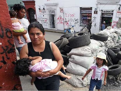 Una familia cruza una barricada del movimiento de protesta de Oaxaca, el pasado martes.