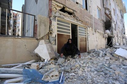 Un hombre sentado entre los escombros de un edificio derrumbado en la ciudad iraní de Sarpol-e Zahab.