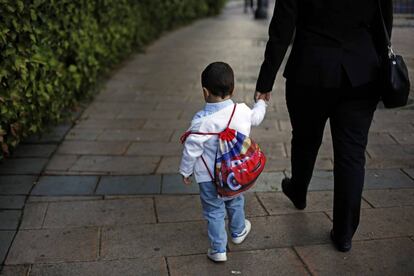 Una madre acompaña a un niño al colegio