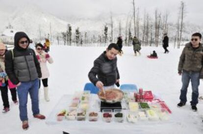 Degustación invernal de un caldero 'hot pot' en la nevada montaña de Xiling, cerca de Chengdu, en la provincia de Sichuan (China).