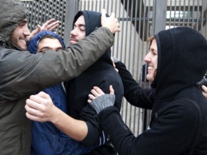 Los amigos de uno de los detenidos le abrazan a la salida de la Ciudad de la Justicia de Valencia.