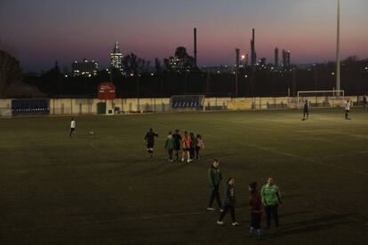 Un entrenemanet al camp del Racing Bonavisat FC. Al fons, la petroquímica.