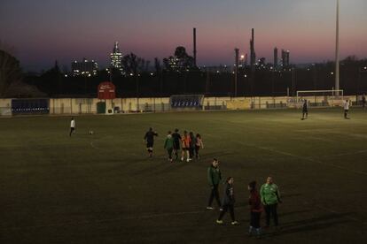 Un entrenemanet al camp del Racing Bonavisat FC. Al fons, la petroquímica. 