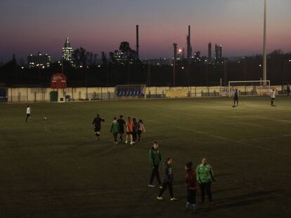 Un entrenemanet al camp del Racing Bonavisat FC. Al fons, la petroquímica. 