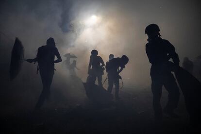 Varios manifestantes rodeados por una nube de gases lacrimógenos, durante un enfrentamiento con la policía en la Universidad China de Hong Kong, el 12 de noviembre de 2019.