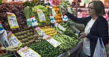 En la imagen, una mujer hace su compra en una fruteria del mercado Maravilla en Madrid.