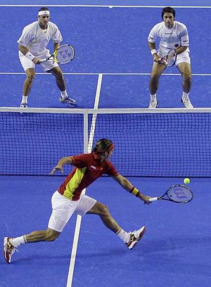 Feliciano devuelve la pelota ante Nalbandian y Calleri.