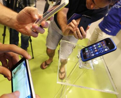 Varias personas miran tel&eacute;fonos m&oacute;viles en una tienda de Madrid.