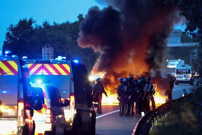 Agentes de policía en formación, frente a una barricada del movimiento 'Bloqueemos todo' en una circunvalación de Nantes. 