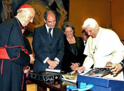 Benedicto XVI observa el libro conmemorativo del Encuentro Mundial de las Familias que le entregó la delegación valenciana, ayer, en el Vaticano.