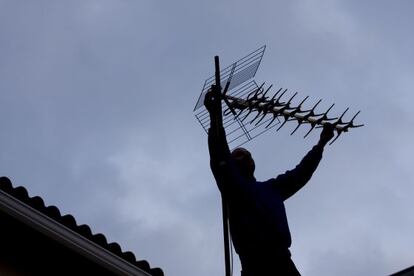 Un home recol&middot;locant una antena de TDT