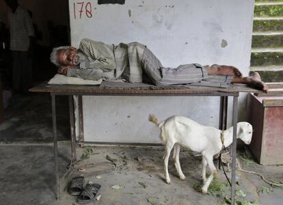 Un hombre descansa en un refugio temporal después de las inundaciones de Allahabad (India).