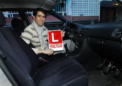 Un joven muestra su L tras aprobar el carnet de conducir.