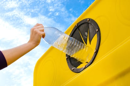 Un ciudadano tira una botella de plástico en el contenedor amarillo.