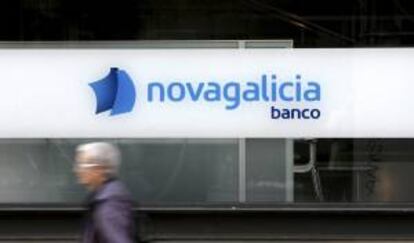 Una mujer pasa por delante de una oficina de Novagalicia Banco. EFE/Archivo