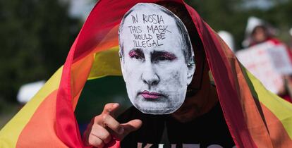 A protester wears a mask featuring a portrait of Russian President Vladimir Putin during the so-called