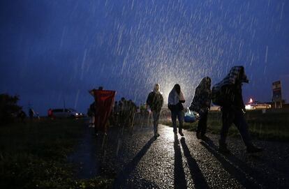 Refugiados llegan a Nickelsdorf durante la noche y bajo la lluvia tras viajar por Hungría en autobuses fletados por el Gobierno húngaro.