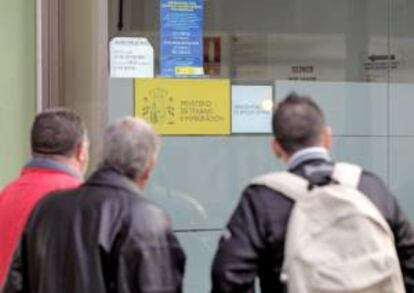 Un grupo de personas mira los carteles de una oficina del INEM en Valencia. EFE/Archivo