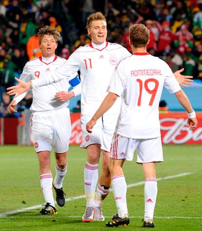 Bendtner, en el centro, es felicitado por sus compañeros Tomasson (izqda.) y Rommedahl tras marcar el 1-1 en el estadio Loftus Versfeld de Pretoria.