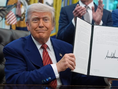 Trump muestra uno de los decretos firmados este viernes en el Despacho Oval de la Casa Blanca.