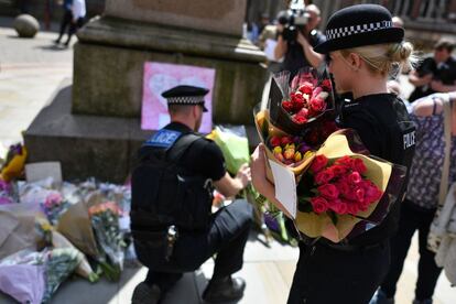 Agentes de la policía de Mánchester llevan flores en St Ann's Square en tributo a las víctimas del atentado del Manchester Arena.