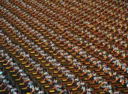 Cientos de chinos realizan el mismo movimiento de percusión durante la ceremonia de apertura.