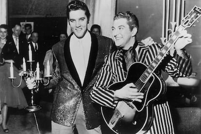 Dos iconos con sus iconos: en esta imagen de 1955 Elvis sostiene un candelabro, elemento que identificaba a Liberace, que solía colocarlos en el escenario y sobre sus pianos, y Liberace posa con una de las guitarras del Rey del Rock.