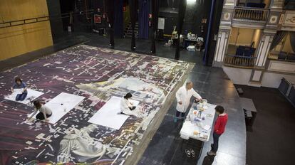 Empleados trabajan en la restauración del telón de boca del Teatro Cervantes de Málaga.