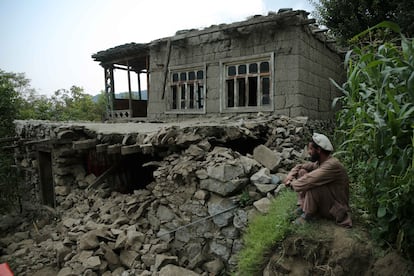 Un hombre junto a una casa dañada por el terremoto de este domingo en Kunar, Afganistán.