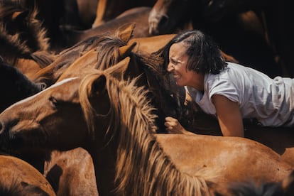 Una mujer sujeta a un caballo salvaje durante el segundo día de la Rapa das Bestas, a 7 de julio. 