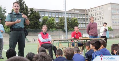 El teniente Jefe de Sección del Seprona de Pontevedra, Álvaro Lago, explica a los pequeños del Balaídos CF cómo prevenir incendios. En la mesa, detrás, el jugador del RC Celta, Iago Aspas.