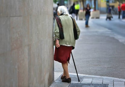 Una anciana pasea por las calles de Valencia. 