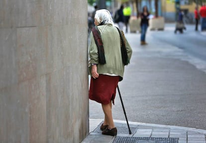 Una anciana pasea por las calles de Valencia.