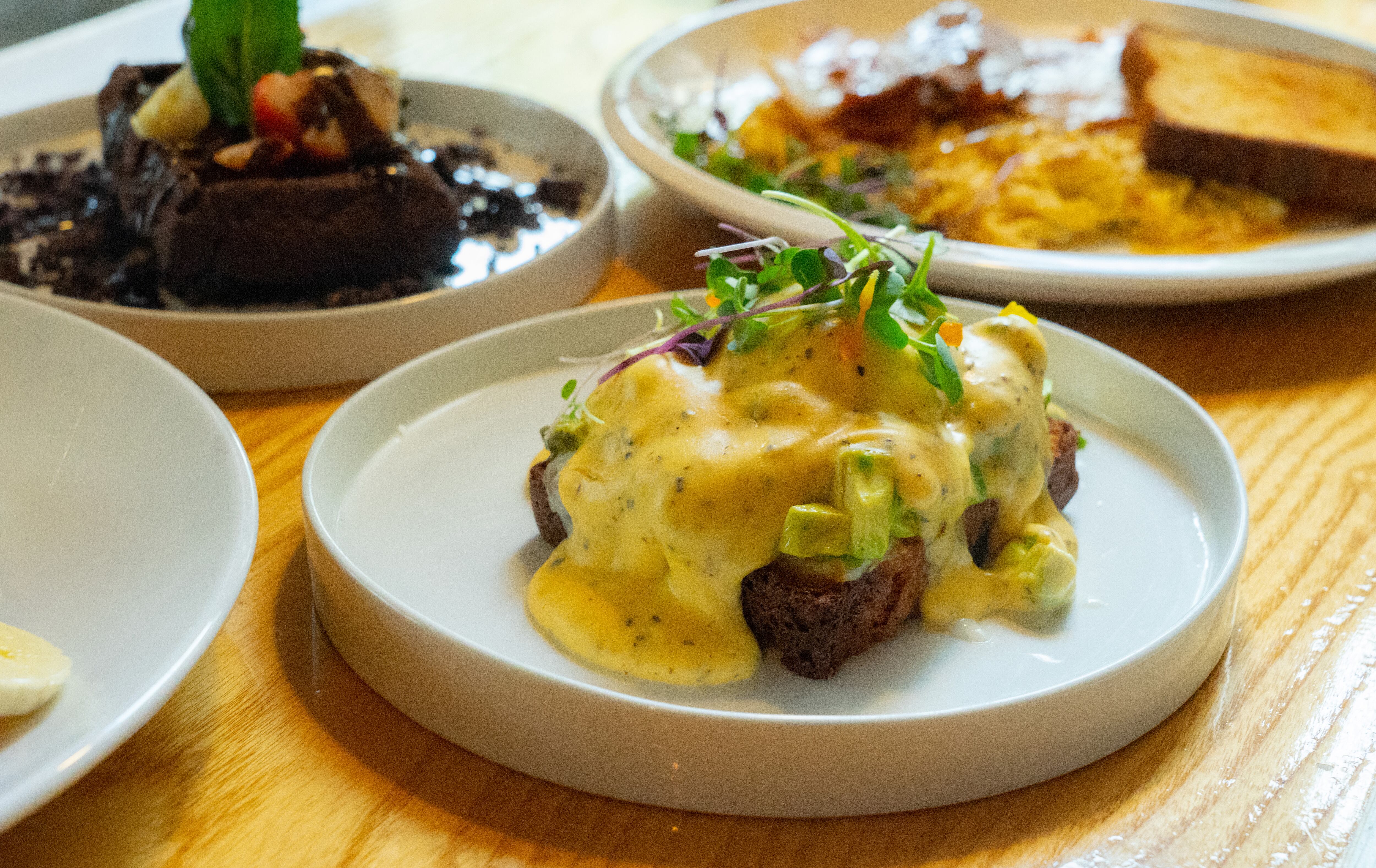 Huevos benedict sobre pan tostado con aguacate y salsa holandesa, uno de los platos del brunch del restaurante La Tape.