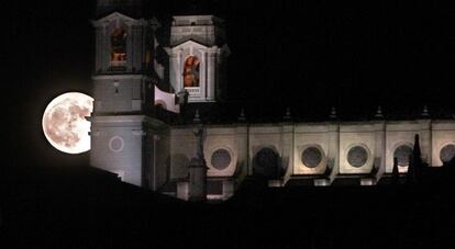 La superlluna surt darrere de la catedral de l'Almudena a Madrid.