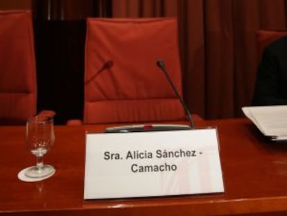 Un cartel con el nombre de la diputada ante su butaca vacía.