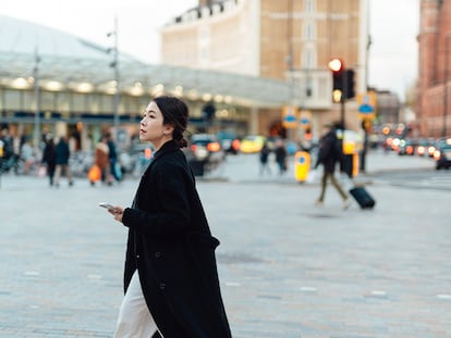 Una chica caminando por las calles de una ciudad con prisa.